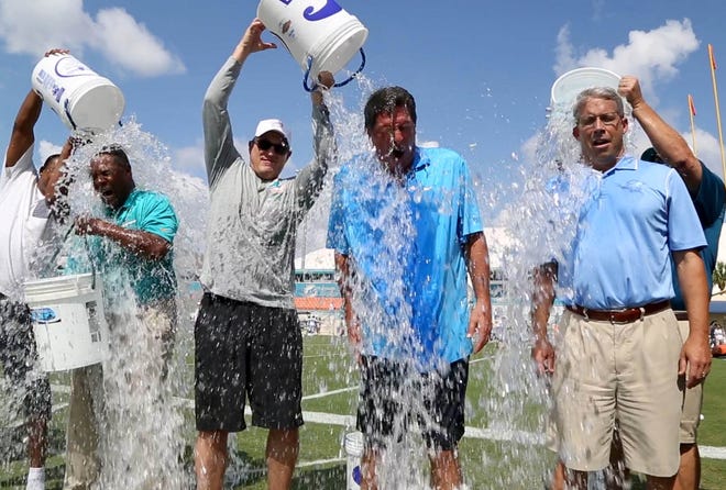 Dolphin alum, Nat Moore, CEO, Tom Garfinkel, former quarterback, Dan Marino, and general manager, Dennis Hickey take part in the Ice Bucket Challenge to raise money for A.L.S. at Dolphins training camp august 2014 in Davie . [ALLEN EYESTONE/palmbeachpost.com]