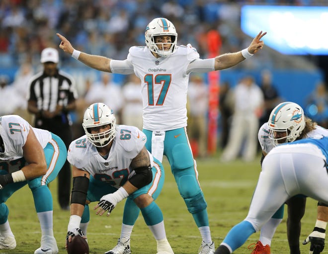 In this Aug. 17 file photo, Miami Dolphins' Ryan Tannehill (17) calls a play at the line of scrimmage, behind center Daniel Kilgore (67) in the first half of an NFL football game against the Carolina Panthers, in Charlotte, N.C. [NELL REDMOND/AP]