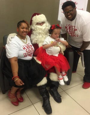Newly adopted Maleah, 6, meets Santa Claus with her new parents, Staci Sessions-Fennell and husband Ajiray Fennell, at the Duval County Courthouse. [Provided by Staci Sessions-Fennell]
