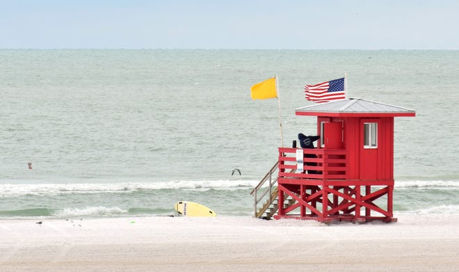 A yellow flag flies at Siesta Beach on Monday. Expect red flags Thursday, as a cold front is expected to bring a dip in temperatures, high winds and heavy rain to the Sarasota-Manatee area beginning Wednesday night. [Herald-Tribune staff photo / Carlos R. Munoz]