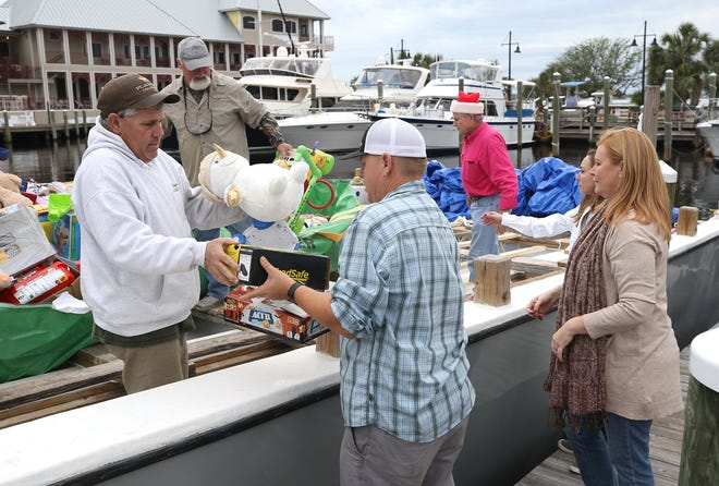 Volunteers unload toys on Dec.19 in St.Andrews. The Operation Santa Boat drove eight hours to deliver about 1,500 toys for children affected by Hurricane Michael in Bay County. The crew made a previous stop in Gulf County to drop of 1,500 other presents for children for a total of 3,000 presents delivered. [PATTI BLAKE/THE NEWS HERALD]