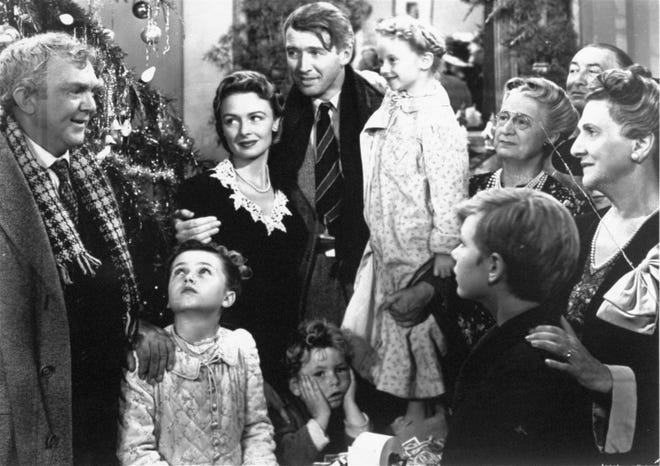 Jimmy Stewart, center, is reunited with his wife, Donna Reed, left, and children during the last scene of Frank Capra's "It's A Wonderful Life." [AP Photo]
