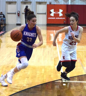 West Holmes' Katie Sprang (left) drives inside to the basket with Hiland's Brynn Mullet covering her move during their non-conference game Saturday at Hiland High. The Hawks topped the Knights 75-20.