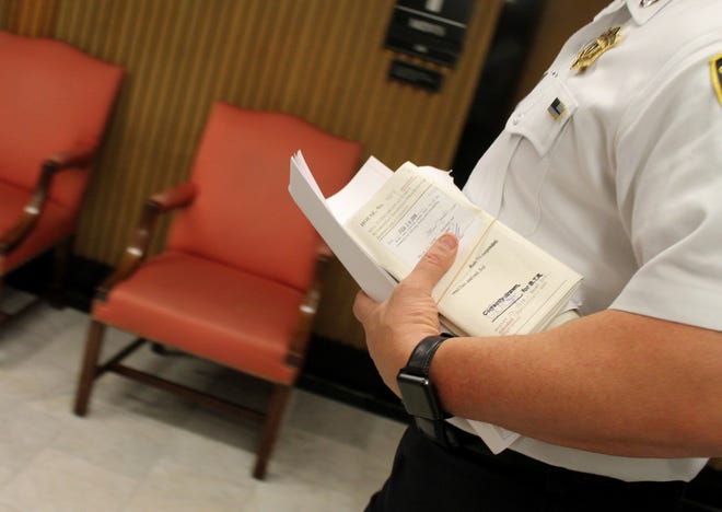 A House court officer shuttled a bundle of bills, including the compromise short-term rental bill, to the Senate during busy informal sessions Thursday afternoon. [State House News Service Photo / Sam Doran]