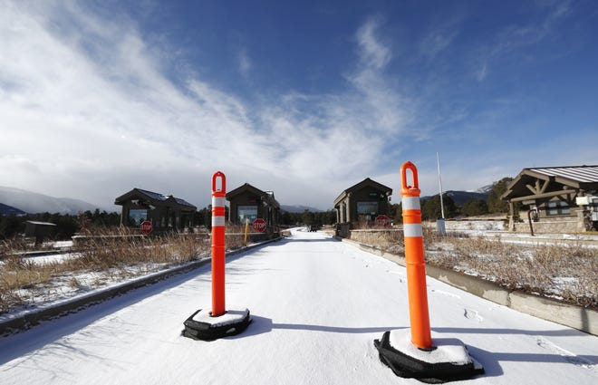 A lane is blocked to an unattended toll booth at Rocky Mountain National Park Saturday, Dec. 22, 2018, in Estes Park, Colo. A partial federal shutdown has been put in motion because of gridlock in Congress over funding for President Donald Trump's Mexican border wall. The gridlock blocks money for nine of 15 Cabinet-level departments and dozens of agencies including the departments of Homeland Security, Transportation, Interior, Agriculture, State and Justice. (AP Photo/David Zalubowski)