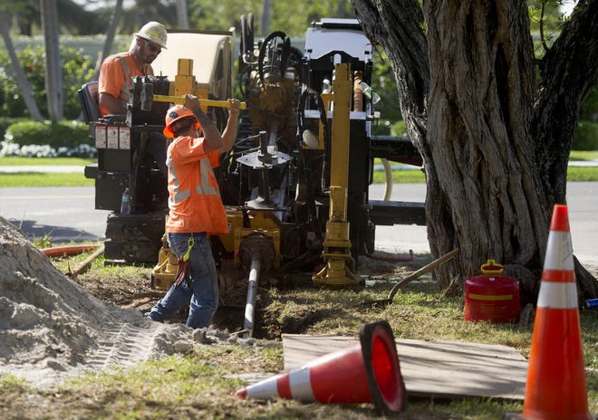 Workers install electrical conduit along Ibis Way as part of the ongoing town-wide burial of utility lines. [Meghan McCarthy/Daily News file photo]