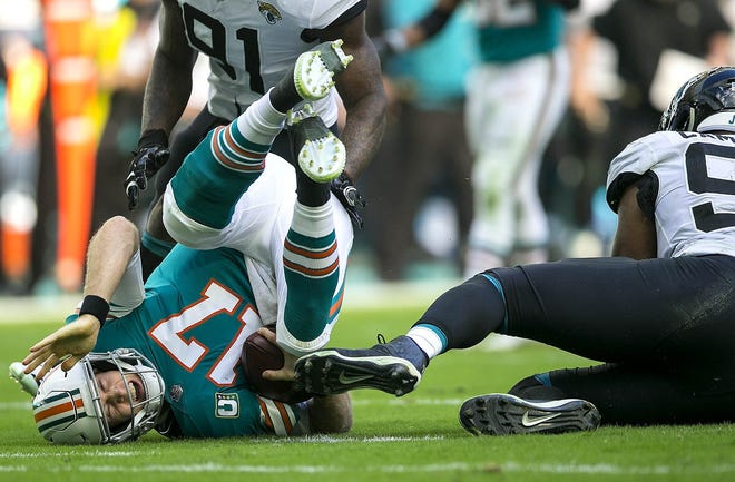 Miami Dolphins quarterback Ryan Tannehill is sacked by Jacksonville Jaguars defensive end Yannick Ngakoue. [BILL INGRAM / palm beachost.com]