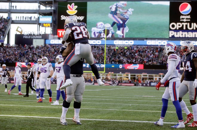 New England Patriots running back James White (28) celebrates his touchdown run with lineman Shaq Mason during the first half of an NFL football game against the Buffalo Bills, Sunday, Dec. 23, 2018, in Foxborough, Mass.