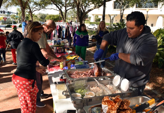 The Sarasota-based nonprofit Streets of Paradise hosted a holiday potluck lunch for the homeless on Sunday afternoon at Five Points Park. Gift cards, sleeping bags, clothing, and hygiene products were provided to those in need. [Herald-Tribune staff photo / Carlos R. Munoz]