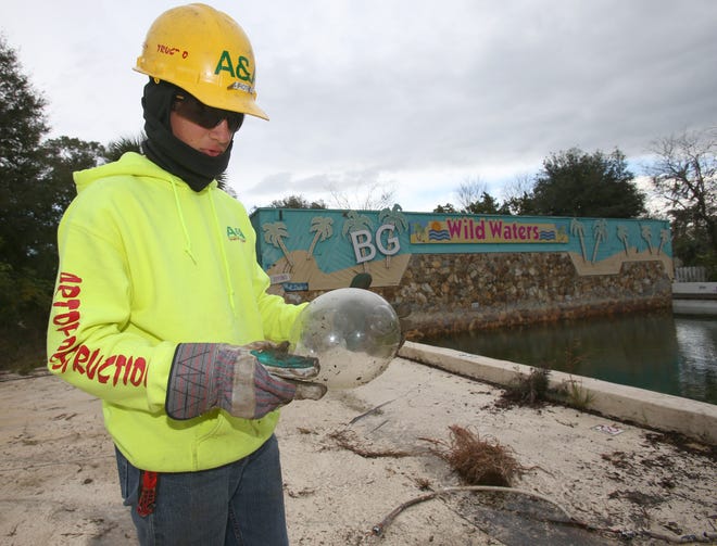 Wyatt Amodeo of A&A "The Art Of Destruction" looks over an old glass fixture from the early 1980s as work begins on the demolition of the old Wild Waters attraction in Silver Springs on Friday. The company will spend about the next two months on demolition of the 40-year-old water park. [Bruce Ackerman/Ocala Star-Banner]