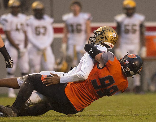 North Davidson's Blake Stephens sacks Shelby quarterback Isaiah Bess in the 2-AA state championship game in Raleigh on Saturday. [Donnie Roberts/The Dispatch]