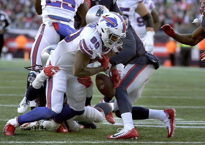 Buffalo Bills tight end Jason Croom (middle) fumbles after catching a pass as he's tackled by Patriots linebacker Dont'a Hightower (left) and defensive back Jason McCourty during the second half of New England's win on Sunday. The victory clinched McCourty's first ever appearance in a playoff game. [AP Photo/Steven Senne]