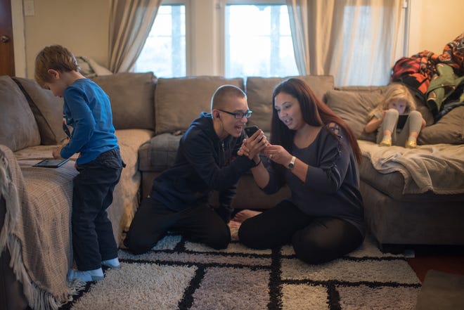 Victoria Perisee-Johns asks her 14-year-old son Cyprian for his cell phone so she can see who he was calling and texting with her other children, Channing, 5, and Amira, 3, during their screen time in their home in Oak Park, Illinois. Perisee-Johns, a therapist who works with police departments as a police crisis worker, is seeing a significant number of parents calling police because they can't settle cell phone or video game disputes with their children. [ROB HART/CHICAGO TRIBUNE/TNS]