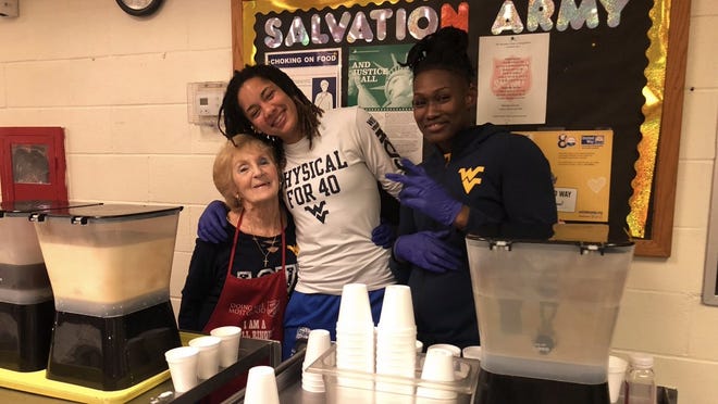 Kari Niblack (center) poses for a picture while taking a break from serving meals and handing out gift bags reccently at a Salvation Army in Morgantown, West Virginia. Niblack was taking part along with her teammates at West Virginia University as part of the team's Hoops N' Heels program. [WEST VIRGINA UNIVERSITY / TWITTER]