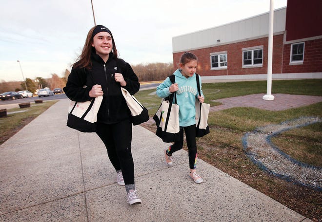 Photo by Daniel Freel/New Jersey Herald
Isobel Costello, a 16-year old Newton High School student, and her sister Magee, 10, carry Weekend Bags from their mother's car to the Green Hills School, where they will be distributed to students in need.