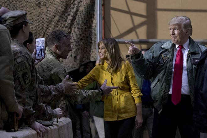 President Donald Trump and first lady Melania Trump greet members of the military at a hanger rally at Al Asad Air Base, Iraq, Wednesday, Dec. 26, 2018. (AP Photo/Andrew Harnik)