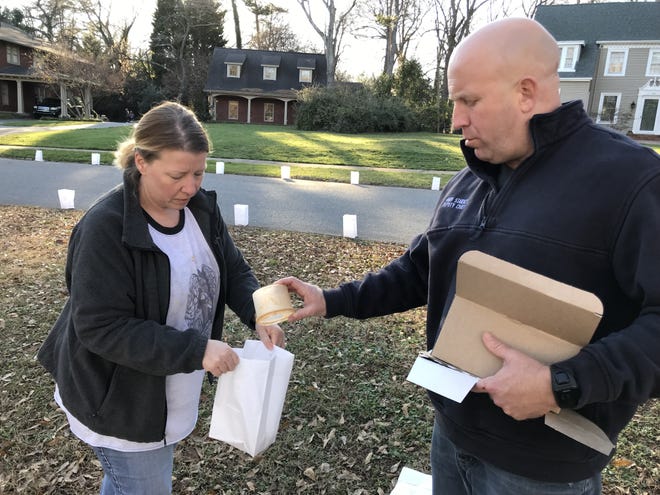 Sarah and Andy Starnes work on putting together luminaries for the Belvedere Park neighorborhood's Christmas Eve tradition. [Joyce Orlando/The Star]