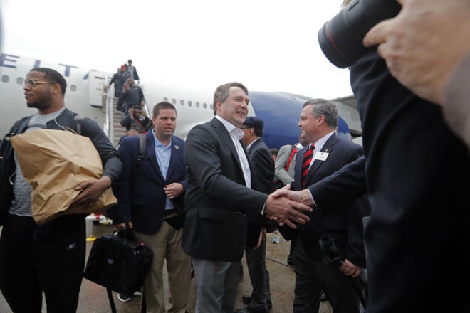 Georgia head coach Kirby Smart, center, is greeted after arriving with his team at Louis Armstrong New Orleans International Airport in Kenner, La., Thursday, Dec. 27, 2018. Georgia will be playing Texas in the upcoming NCAA football Sugar Bowl game on New Year's day. (AP Photo/Gerald Herbert)