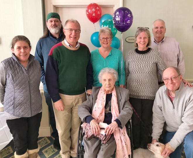 Centenarian Anne Wallack is seated in the front center. The others are, left to right: Barbara Warren, grandson Jason Wallack, son Bob Wallack and his wife Maryellen Wallack, Kathleen Skinner, David Skinner, Phil Skinner and dog Carly (after Carly Simon). They are at Alliance Health at Marina Bay in Quincy.