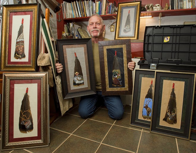 Ronald Willis of WILLASART poses with a few of his numerous painted turkey feathers at his home studio in Churchland. [Donnie Roberts/The Dispatch]