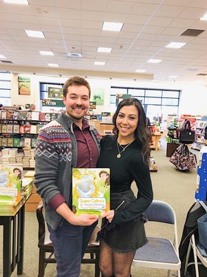 Dr. Kevin Gendreau, a family medicine physician at Southcoast Health Fairhaven, and nurse Monique Borges, the inspiration for Queen Celine, hold "Queen Celine's Vaccine Machine", a children's book written by Gendreau, at a recent book signing. [Submitted Photo]