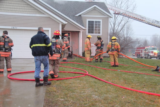 Zeeland Township firefighters battle a house fire in the 2000th block of Dover Lane on Friday. A dog died due to the fire. [Erin Dietzer/Sentinel staff]