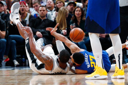 San Antonio Spurs forward LaMarcus Aldridge, left, competes for control of a loose ball with Denver Nuggets guard Jamal Murray during the second half of an NBA basketball game Friday, Dec. 28, 2018, in Denver. The Nuggets won 102-99. (AP Photo/David Zalubowski)