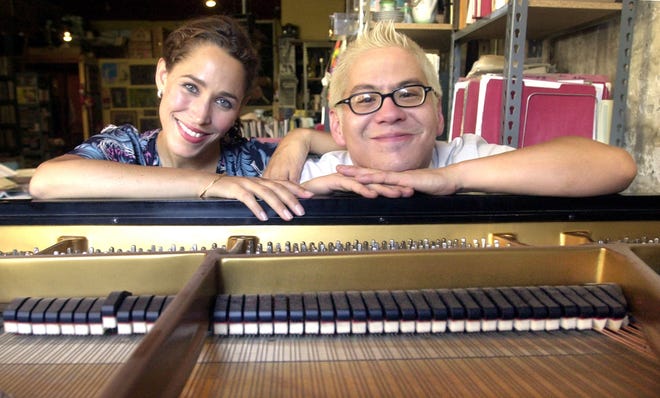 Thomas Lauderdale, right, poses with fellow Pink Martini musician China Forbes at the piano in his loft apartment in Portland, Ore. Pink Martini has won international accolades for its melding of jazz, classical, French cafe standards and Afro-Cuban rhumba. The band will be in concert on New Year's Eve at the Walt Disney Concert Hall in Los Angeles. [AP Photo/Don Ryan]