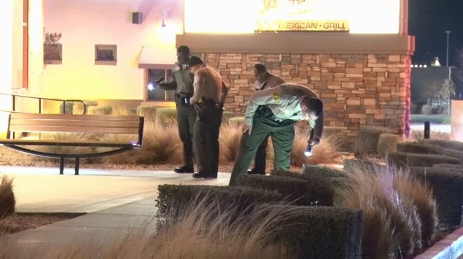 A Sheriff's deputy searches for evidence outside after a shooting occurred at BJ's Restaurant and Brewhouse in Victorville early Saturday morning. [Lewis Busch, LLN News]