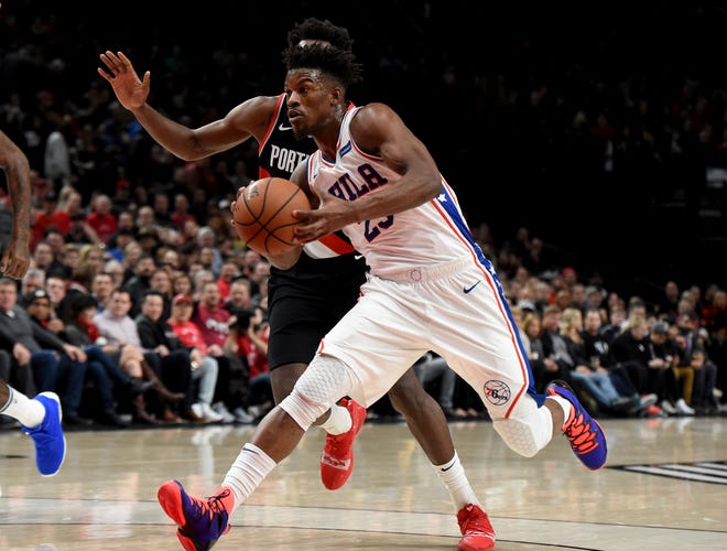 Sixers guard Jimmy Butler drives to the basket past Portland Trail Blazers forward Al-Farouq Aminu during Sunday's game. Butler struggled through a 2 for 12 shooting night to finish with just five points, as the Sixers lost 129-95. [STEVE DYKES / THE ASSOCIATED PRESS]