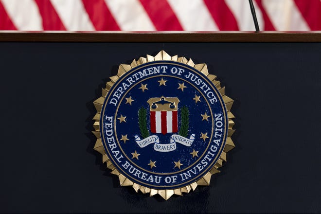 FILE - In this June 14, 2018, file photo, the FBI seal is seen before a news conference at FBI headquarters in Washington. The FBI is grappling with a seemingly endless cycle of money laundering schemes that law enforcement officials say they're scrambling to slow through a combination of prosecution and public awareness. Beyond the run-of-the-mill plots, officials say, is a particularly concerning trend involving 'money mules.' These are people who, unwittingly or not, use their own bank accounts to move money for criminals for purposes they think are legitimate or even noble. (AP Photo/Jose Luis Magana, File)