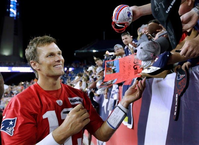 In this July 30, 2018 photo, New England Patriots quarterback Tom Brady signs autographs for fans following an NFL football practice at Gillette Stadium, in Foxboro, Mass. After the star quarterback signed Megan Uhrynowski's arm during training camp last summer, she decided to make the ink permanent and had Brady's scrawled autograph turned into a tattoo on the inside of her wrist. The unusual decision ranked among New England's odd stories in 2018. [Steven Senne/AP Photo]