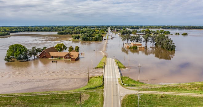 Flood waters from Cow Creek cover 56th Avenue Thursday morning, Oct. 11, 2018, closing Pennington Rd. next to Mitchell United Methodist Church, left, and the Kansas Bible Camp East Campus, right. [Photo courtesy Nick Hemphill]