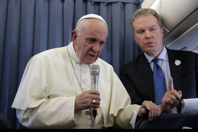 FILE - In this Sunday, Aug. 26, 2018 file photo, Pope Francis, flanked by Vatican spokesperson Greg Burke, listens to a journalist's question during a press conference aboard of the flight to Rome at the end of his two-day visit to Ireland. The Vatican spokesman, Greg Burke, and his deputy resigned suddenly Monday, Dec. 31, 2018 amid an overhaul of the Vatican's communications operations that coincides with a troubled period in Pope Francis' papacy. In a tweet, Burke said he and his deputy, Paloma Garcia Ovejero, had resigned effective Jan. 1. (AP Photo/Gregorio Borgia, Pool)