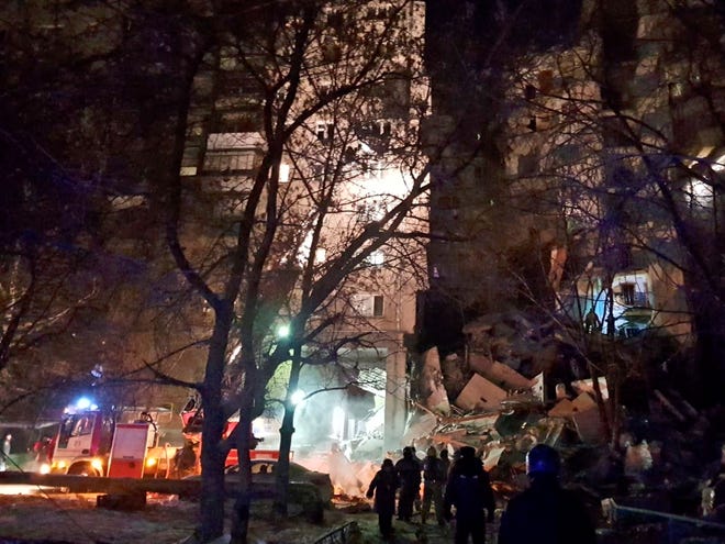 This photo provided by www.verstov.info shows Emergency Situations employees working at the scene of a collapsed apartment building in Magnitogorsk, a city of 400,000 people, about 1,400 kilometers (870 miles) southeast of Moscow, Russia, Monday, Dec. 31, 2018. Russian emergency officials say that at least four people have died after sections of the apartment building collapsed after an apparent gas explosion in the Ural Mountains region. (verstov.ru photo via AP)