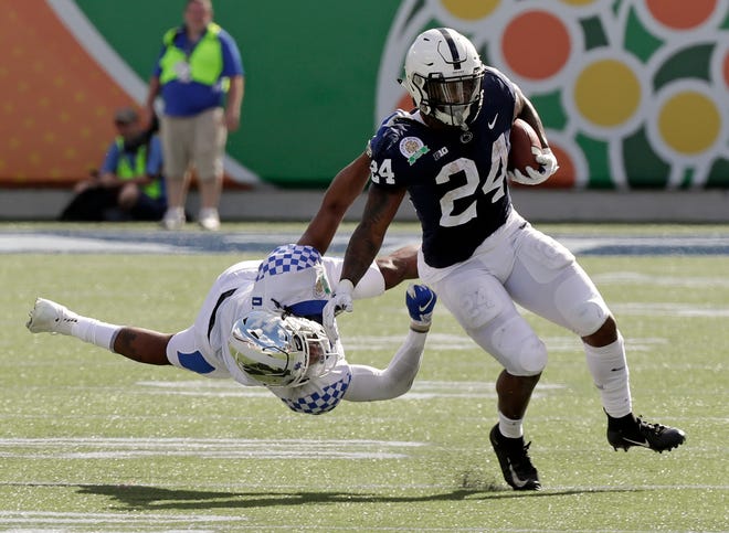 Kentucky safety Davonte Robinson, left, stops Penn State running back Miles Sanders (24) after a short gain during the first half of the Citrus Bowl NCAA college football game, Tuesday, Jan. 1, 2019, in Orlando, Fla. (AP Photo/John Raoux)