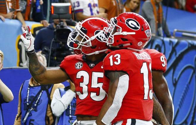 Georgia running back Brian Herrien (35) celebrates his touchdown with running back Elijah Holyfield (13) during the first half of the Sugar Bowl NCAA college football game against Texas in New Orleans, Tuesday, Jan. 1, 2019. (AP Photo/Butch Dill)