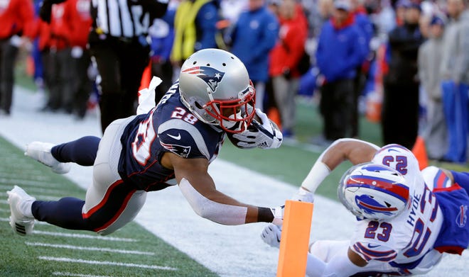 New England Patriots running back James White (28) dives to the pylon for a touchdown in front of Buffalo Bills safety Micah Hyde (23) during the first half of an NFL football game, Sunday, Dec. 23, 2018, in Foxborough, Mass. (AP Photo/Steven Senne)