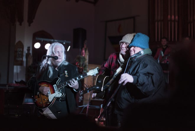 Mark Marquis, left, organizer of “The Most Peaceful Night of the Year: Mark Marquis and Friends,” look on Johnny Girouard, center, and Mike “Spud” Kelly, perform as the Lee Twins. [EMILY JOY ASHMAN PHOTO]