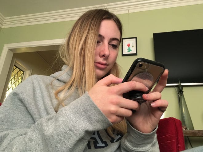 Laurel Foster holds her phone in San Francisco. Foster is among teens involved in Stanford University research testing whether smartphones can be used to help detect depression and potential self-harm. [Haven Daley/AP Photo]