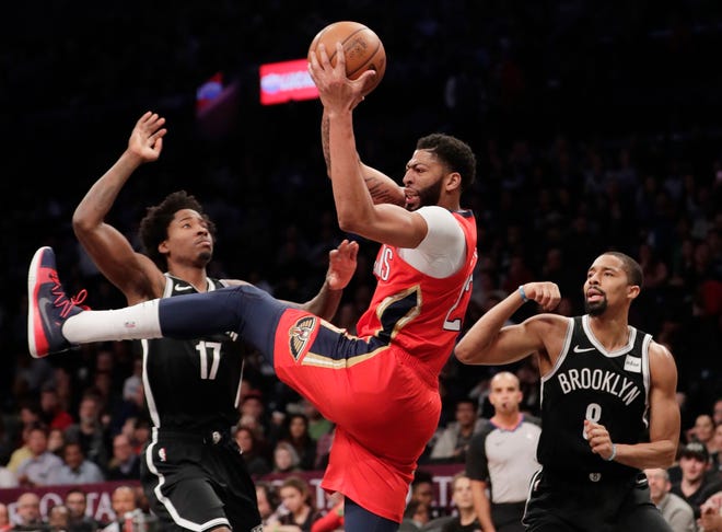 New Orleans Pelicans' Anthony Davis (23) rebounds the ball as Brooklyn Nets' Ed Davis (17) and Spencer Dinwiddie (8) watch during the first half of an NBA basketball game Wednesday, Jan. 2, 2019, in New York. (AP Photo/Frank Franklin II)