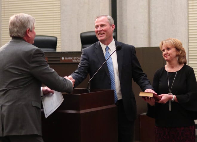 Jim Couch, left, administered the oath of office for new City Manager Craig Freeman on Wednesday. Freeman's wife, Rhonda, held the Bible. Freeman took over as Couch retired after 31 years with the city and 18 years as its top administrator. [Photo by Doug Hoke, The Oklahoman]