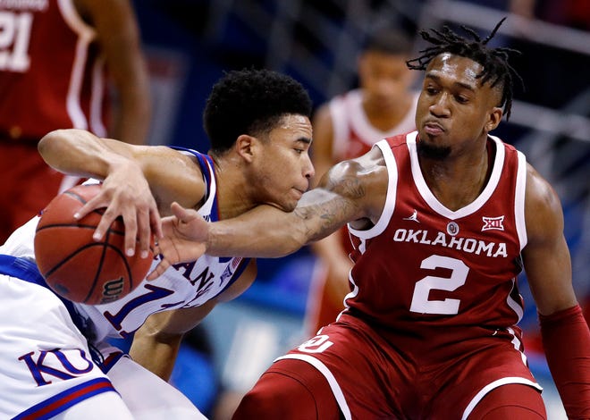 Oklahoma's Aaron Calixte (2) tries to steal the ball from Kansas' Devon Dotson (11) during the second half of an NCAA college basketball game Wednesday, Jan. 2, 2019, in Lawrence, Kan. Kansas won 70-63. (AP Photo/Charlie Riedel)