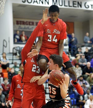 Cathedral Prep's Liam Galla, with ball, uses a head fake to force St. Rita's Javon Cooley up in the air during the second game of the Burger King Classic last year. This year's Burger King Classic is set for Jan. 18-19. [GREG WOHLFORD/ERIE TIMES-NEWS]