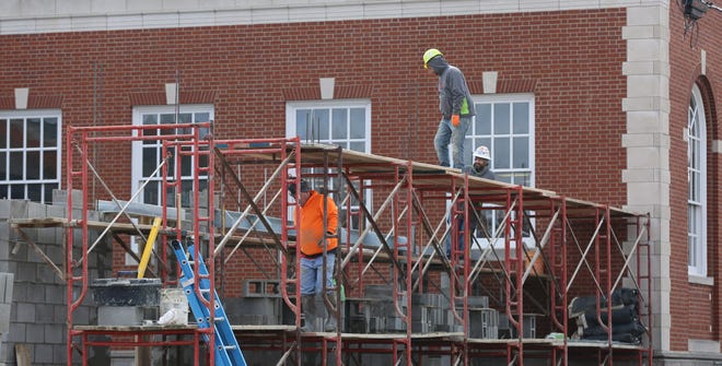 The weather is not an option right now for workers completing the expansion project at the Tuscarawas County Library in New Philadelphia. (TimesReporter.com / Hank Keathley)