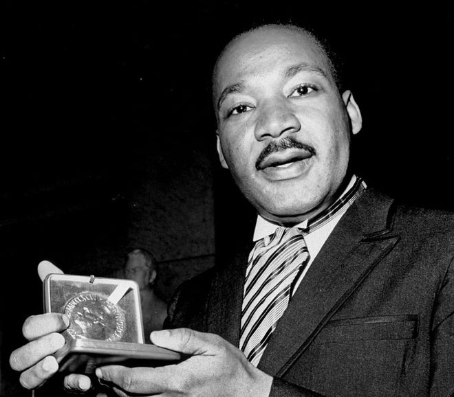 In this Dec. 10, 1964, file photo, U.S. civil rights leader Dr. Martin Luther King, Jr. holds his 1964 Nobel Peace Prize medal in Oslo, Norway. King was honored for promoting the principle of non-violence in the civil rights movement.