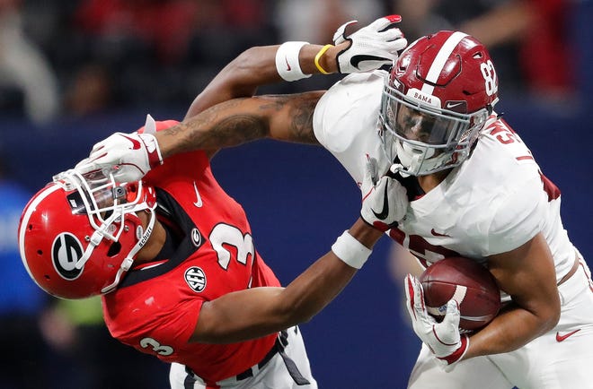 FILE - In this Dec. 1, 2018, file photo, Alabama tight end Irv Smith Jr. (82) hits Georgia defensive back Tyson Campbell (3) in the helmet during the first half of the Southeastern Conference championship NCAA college football game, in Atlanta. Irv Smith Jr. was determined to be a wide receiver in high school. Never mind that heâ€™s the son and nephew of former NFL tight ends and is built for that position, too. He caved to the reality his junior year at Brother Martin High School in New Orleans and moved to the familyâ€™s favored position fulltime. Now, he has become a dangerous option for the Crimson Tide as both a pass catcher and blocker heading into Monday nightâ€™s national championship game against Clemson in Santa Clara, California.(AP Photo/John Bazemore, File)