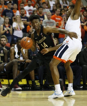 Florida State guard Terance Mann (14) gets around Virginia guard De'Andre Hunter (12) during the second half Saturday in Charlottesville, Va. Virginia defeated Florida State 65-52. [The Associated Press / Steve Helber]