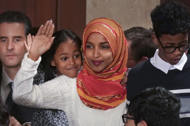 Rep. Ilhan Omar, center, a freshman Democrat representing Minnesota's 5th Congressional District, is sworn in on the House floor by new House Speaker Nancy Pelosi on the first day of the 116th Congress Jan. 3 at the Capitol in Washington. [The Associated Press]