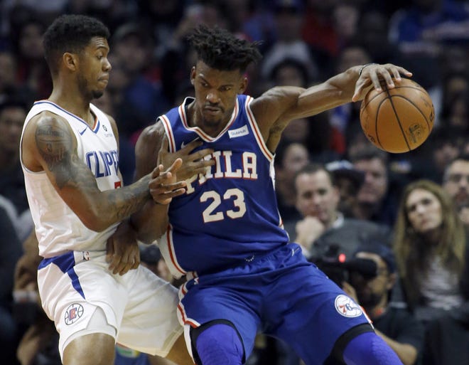 The Sixers' Jimmy Butler protects the ball from the Clippers' Tyrone Wallace during Tuesday's game in Los Angeles. [ALEX GALLARDO / THE ASSOCIATED PRESS]